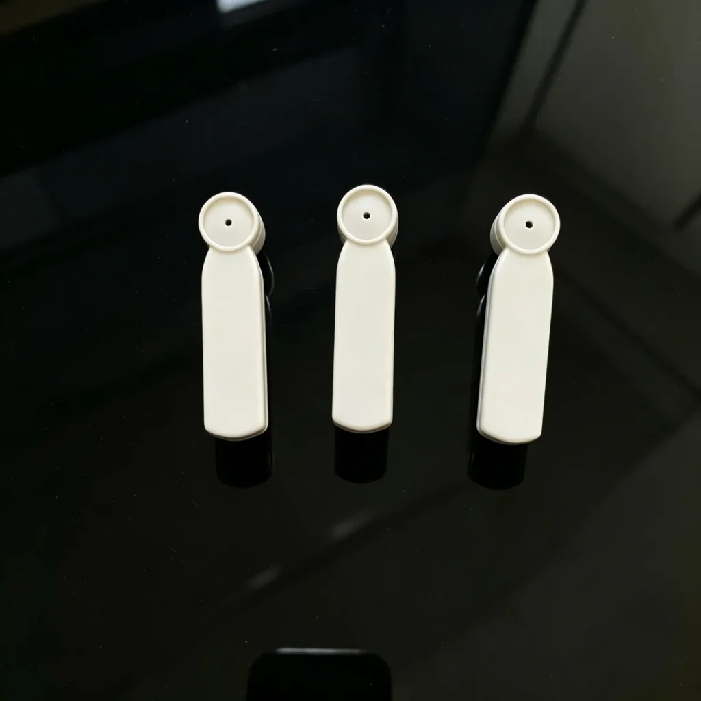 Flat lay of multiple Lionyouge AM medium pencil bullet EAS tags, 53mm medium hammer hard tags for supermarket clothing retail